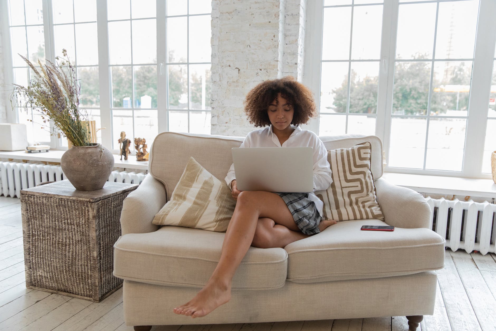 woman sitting on a couch using a laptop